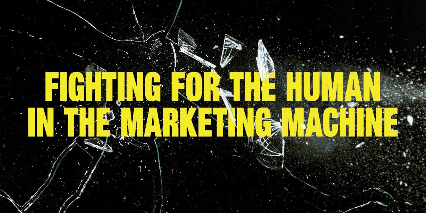 Black background with smashed glass. Text reads 'Fighting for the Human in the Marketing Machine'